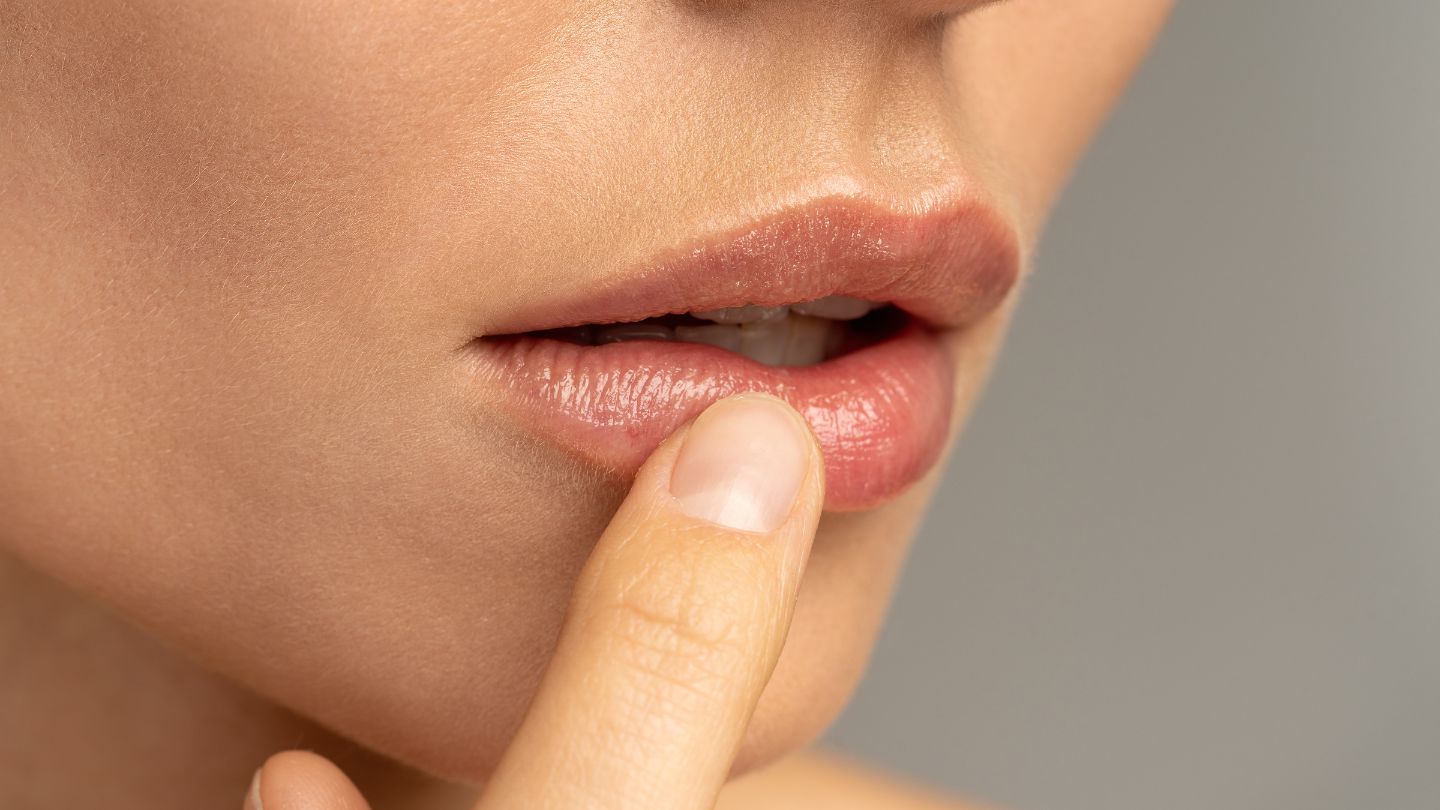 Lip close up of woman putting on vitamin e
