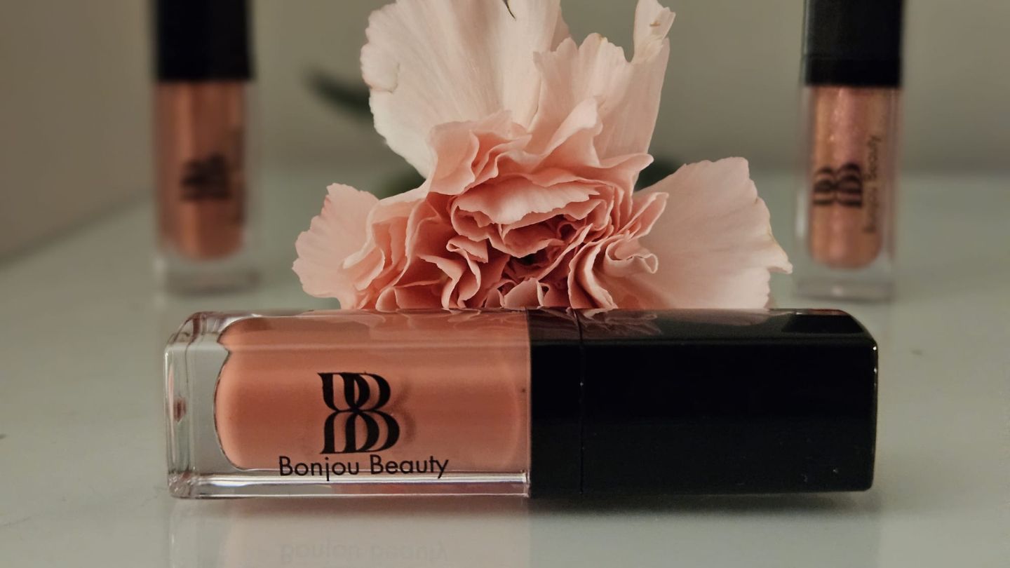 Lip gloss trio with flower on counter for Makeup collection safe for teen skin