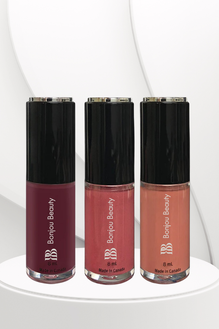 Three bottles of Bonjou Beauty lip gloss on a white background