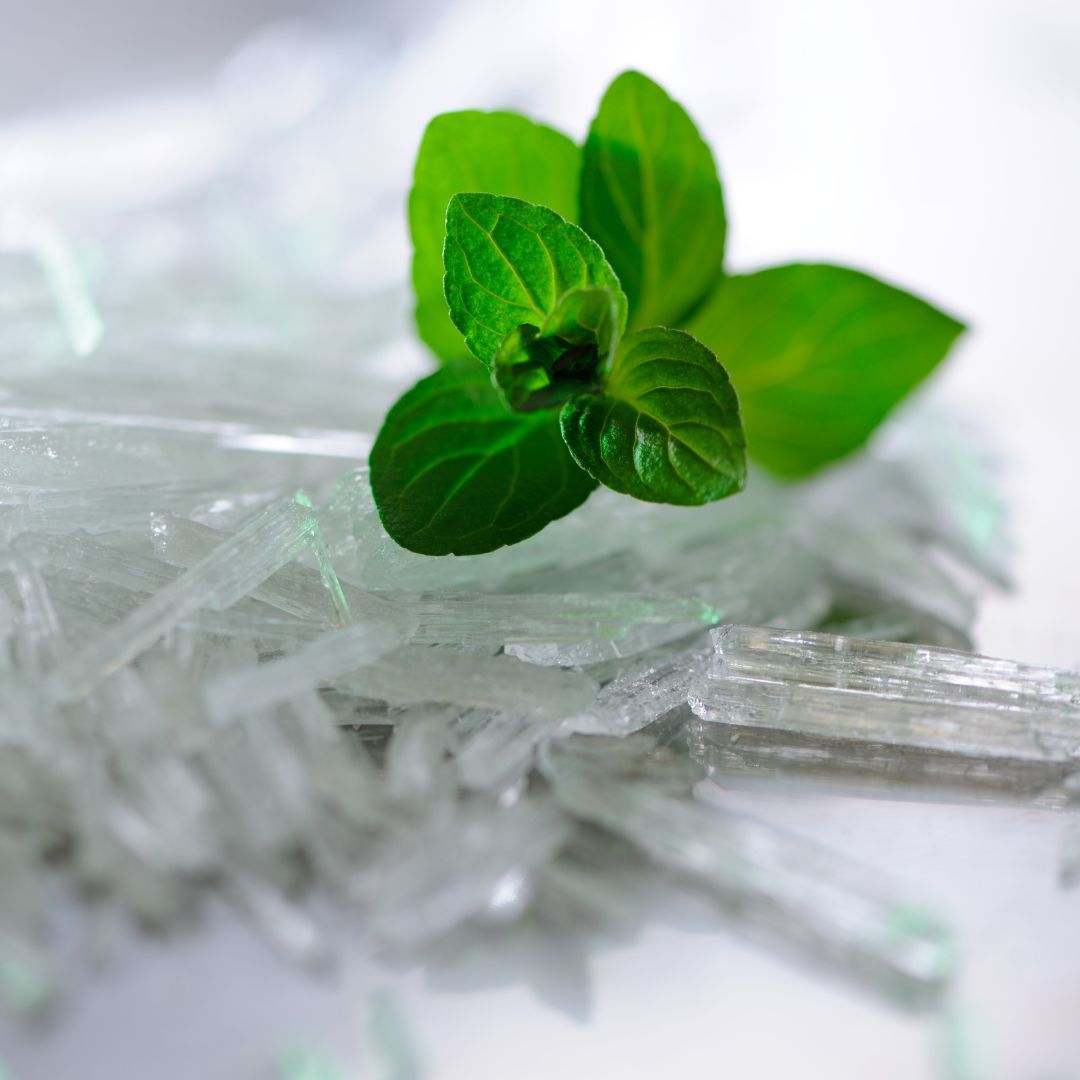 Sprig of mint and crystals on a silver table
