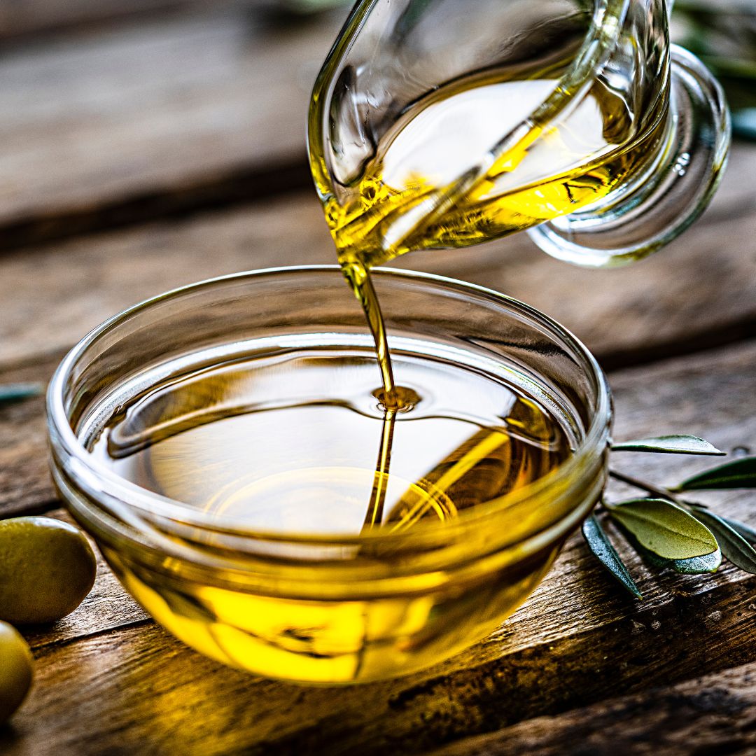 Olive oil pouring into glass bowl