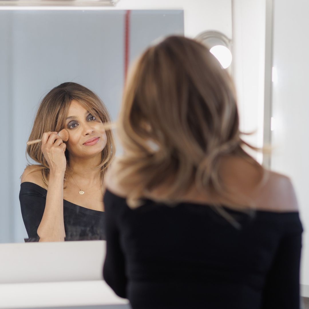 Samantha putting on 3 in 1 Beauty Stix in a mirror