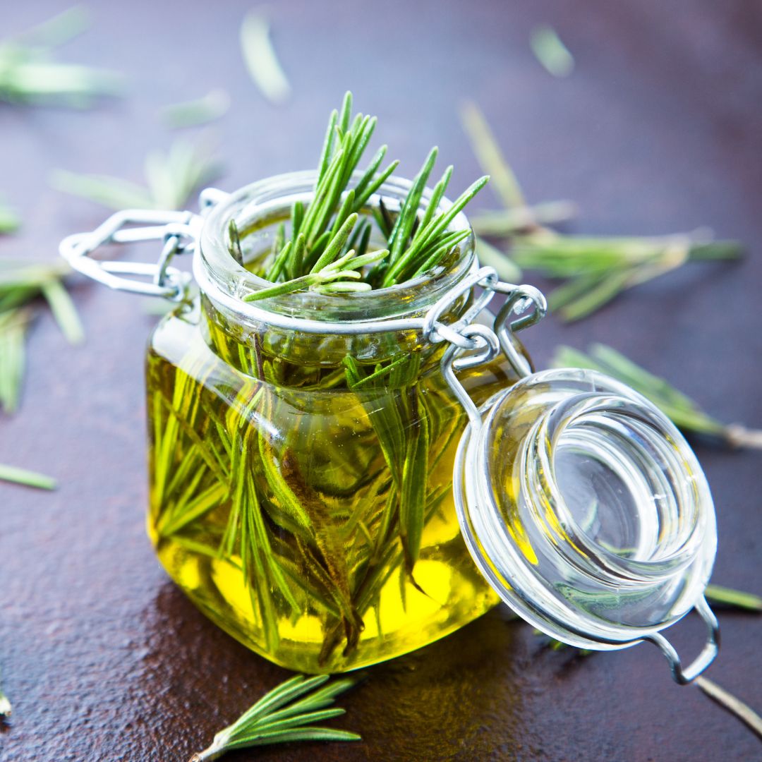 Rosemary Oil with rosemary leaves on a table