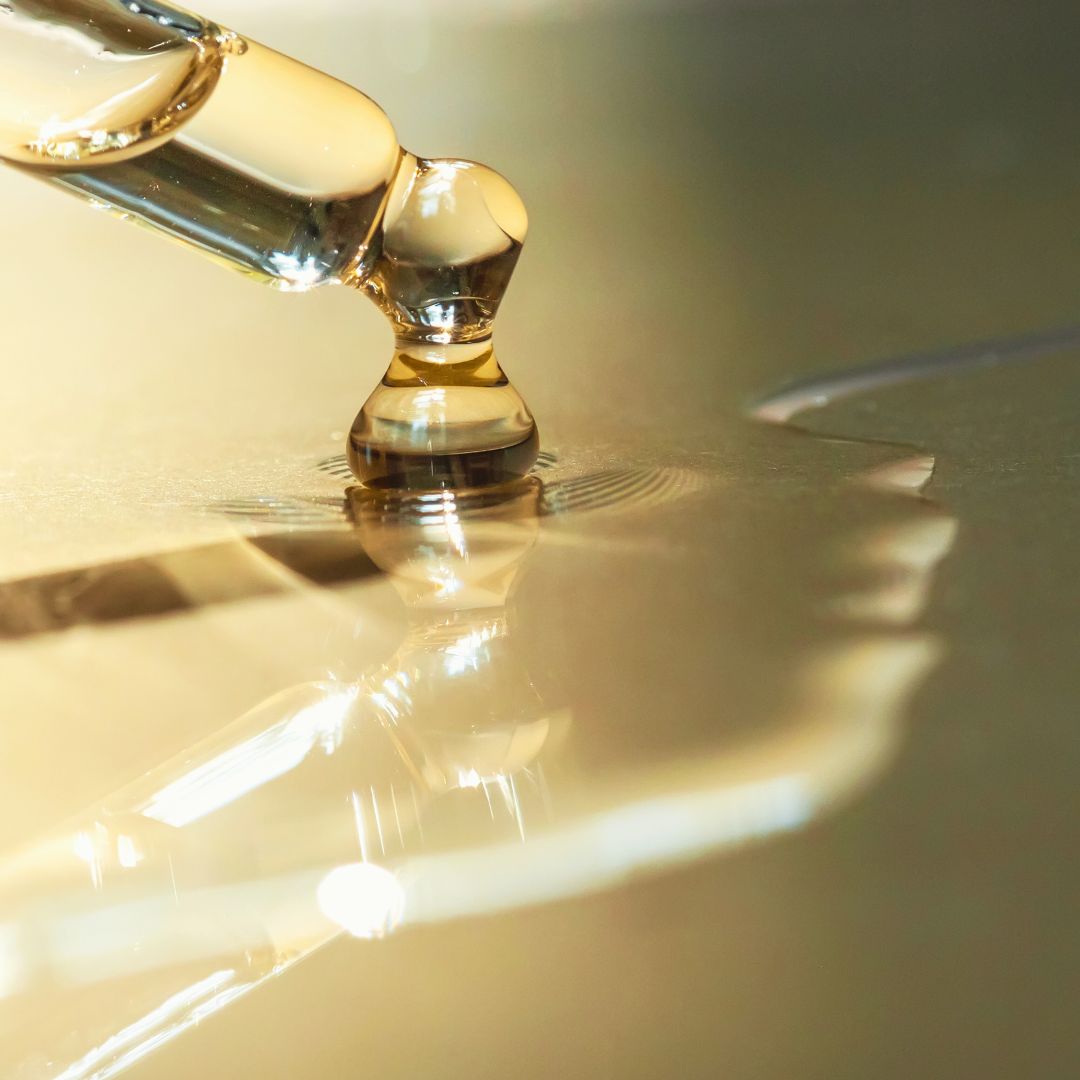 Dropper with Vitamin A oil dripping onto table