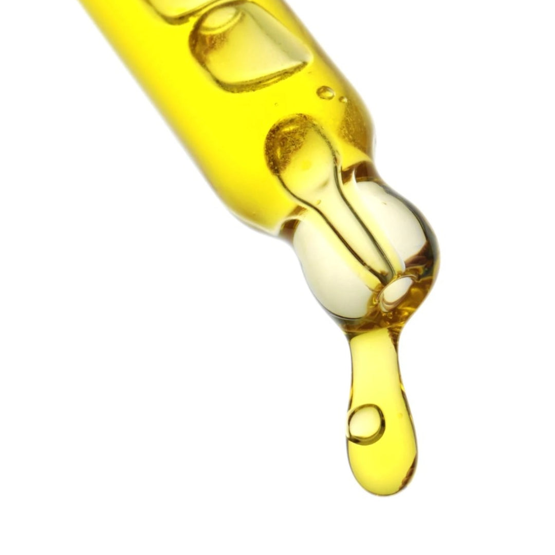 Vitamn C oil dripping from droper on white background