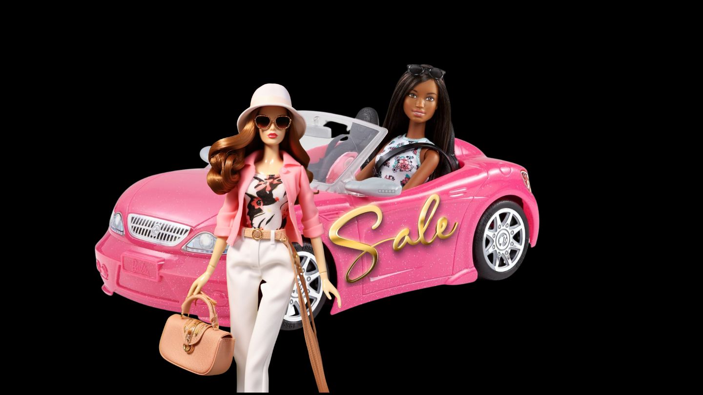 Two dolls, one in a pink tow car and the other walking on a dark background
