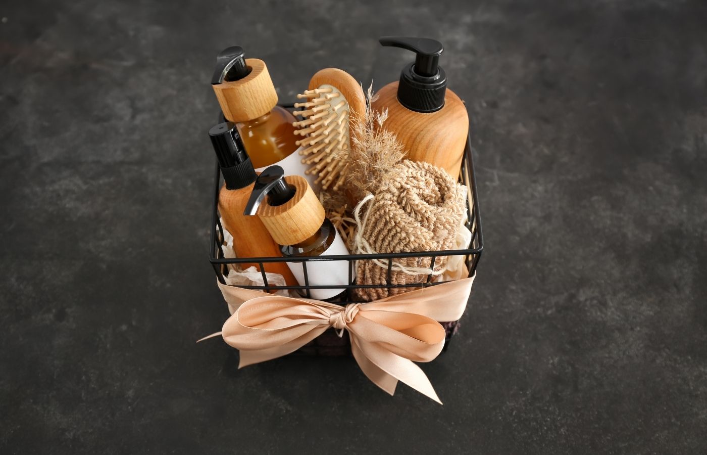 skincare products a brush and towel in a basket on a dark table