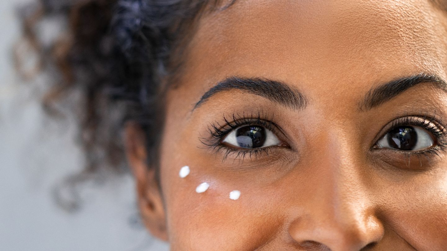 close up of woman in early 40s with eye cream