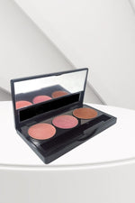 Makeup palette with four round applicators on a white surface