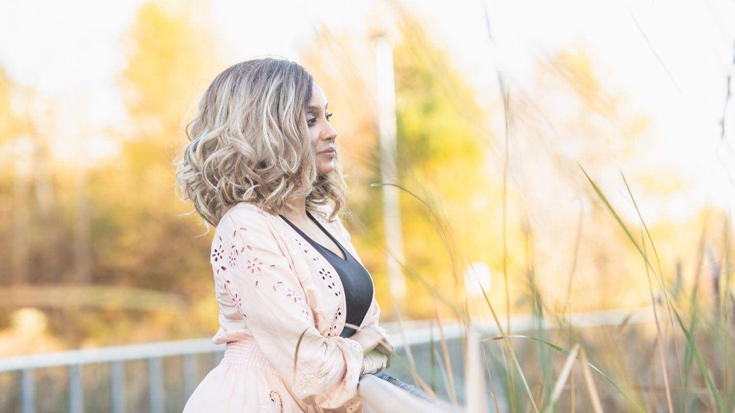 Woman standing outdoors with blurred natural background