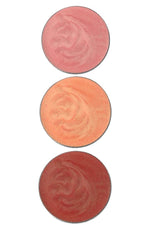 Three round eyeshadow shades in pinkish-peach, peach and sienna on a white background