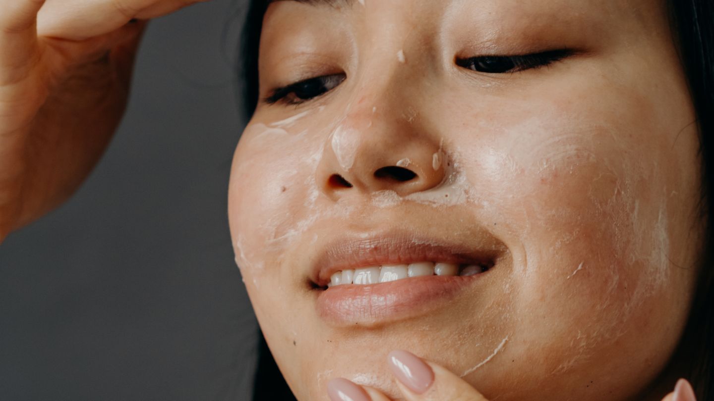 Close up of woman putting Moisture Boost Day Cream on her face