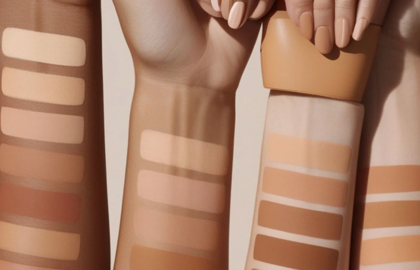 Three swatches of makeup on a person's arm with a neutral background