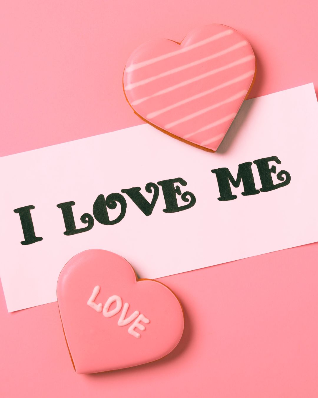 Heart-shaped cookies with 'I Love Me' text on a pink background