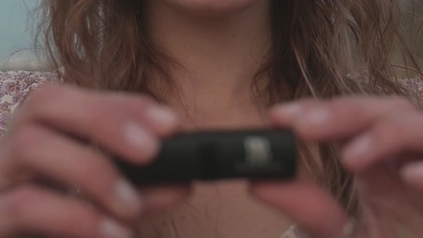 Woman opening a tube of Bonjou Beauty lipstick